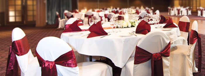 Chairs and tables with red sashes and napkins